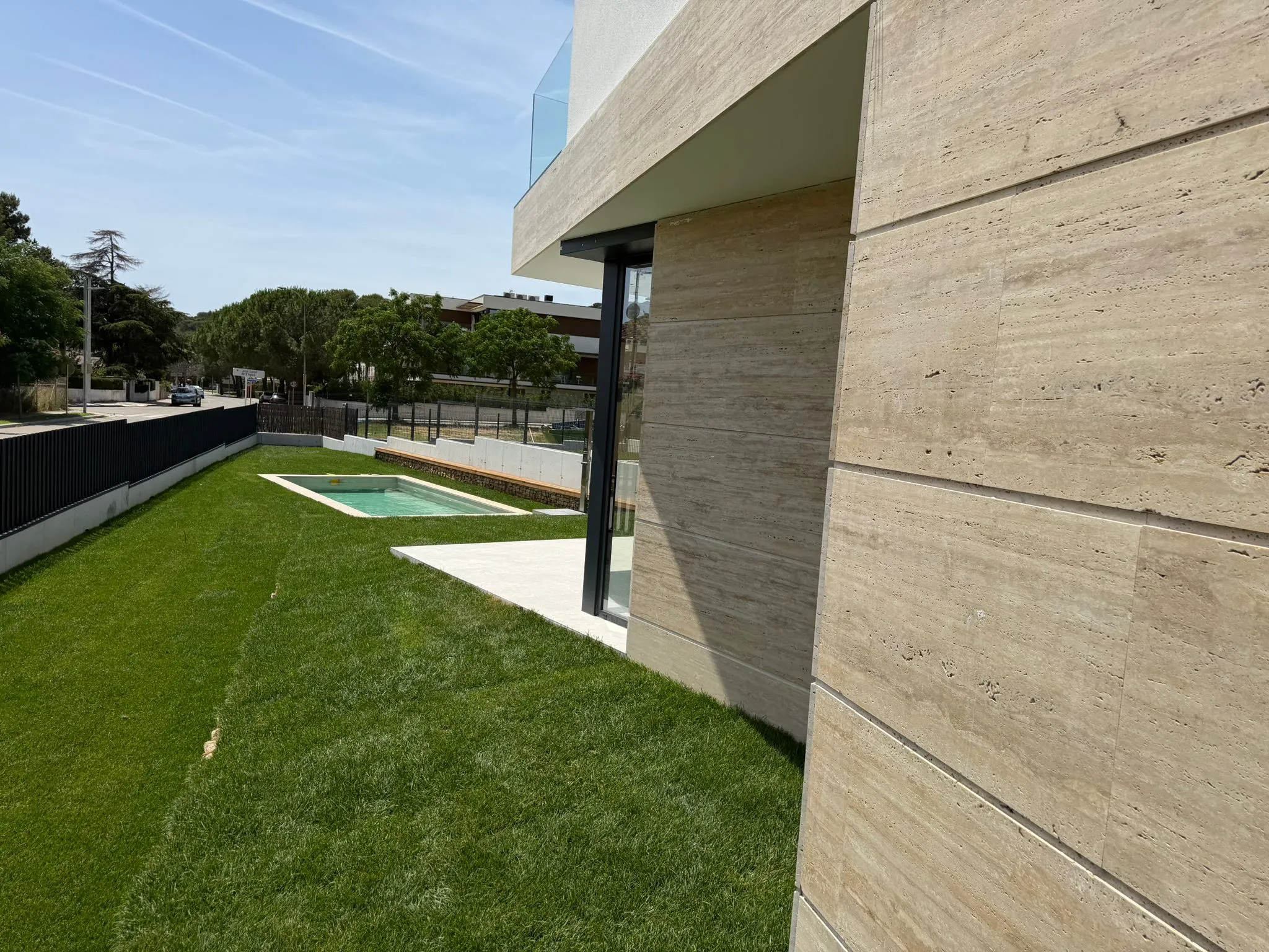 Fachada de travertino, con el césped puesto